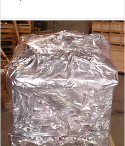 Industrial aluminum barrier foil vacuum packaging film wrapped over large export machinery on a wooden pallet crate